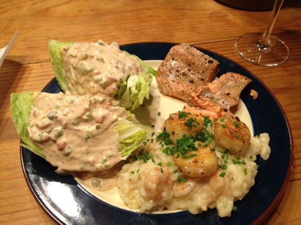 salmon dinner with scallop and shrimp seafood risotto and a thousand island wedge